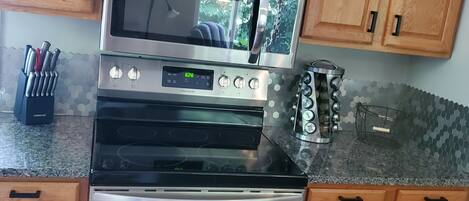 A kitchen with wooden cabinets, a microwave, a stove, and a built-in oven.