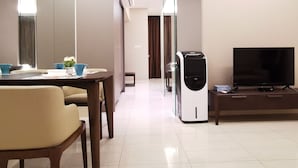 Una habitación de hotel moderna con comedor, televisión de pantalla plana y una kitchenette.