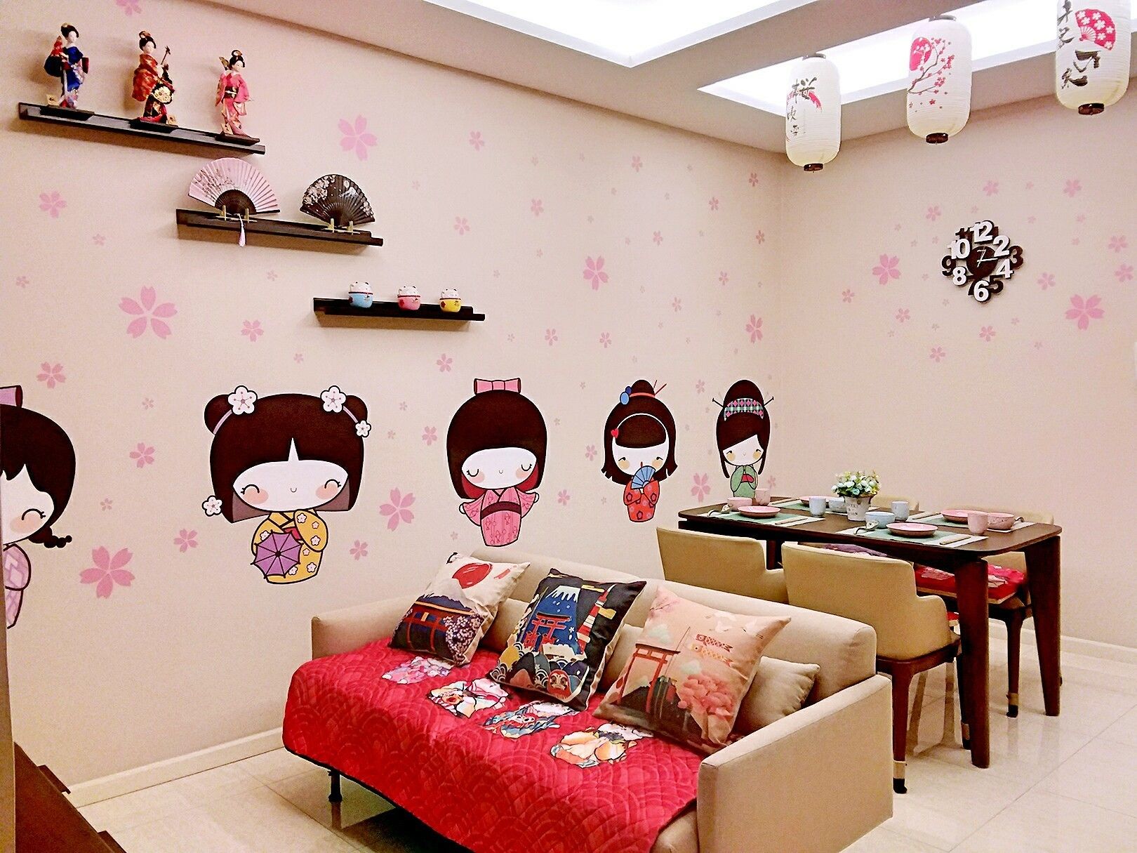 A living room with a sofa, a dining table, and decorative wall stickers.