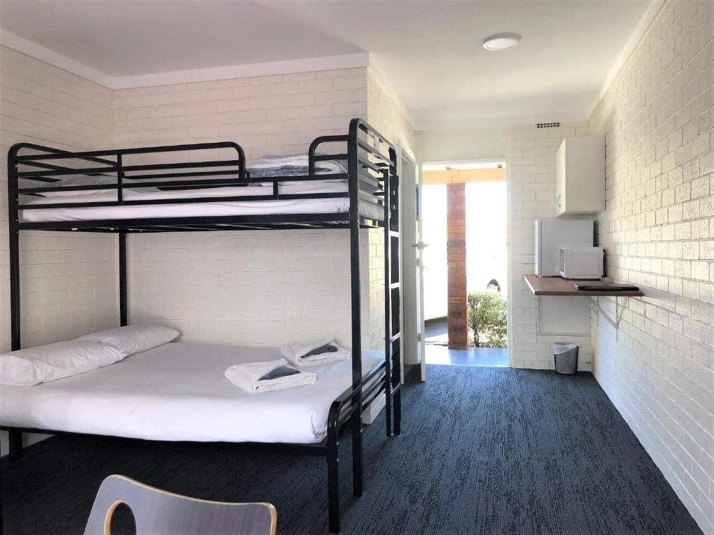Een slaapkamer met stapelbed, bureau en televisie.