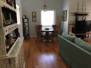 Relax in this inviting living room with a sofa, dining table, and TV.