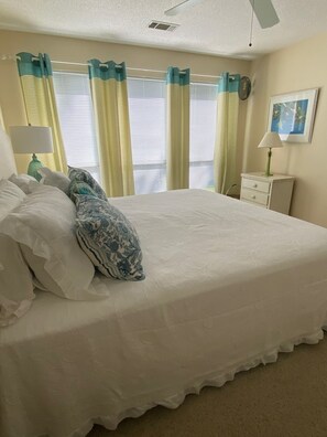 Cozy retreat with a large bed, bedside tables, and a ceiling fan.