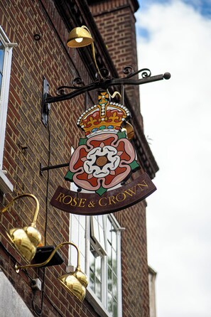 Un edificio con un letrero llamativo que muestra una corona y las palabras "ROSE & CROWN".