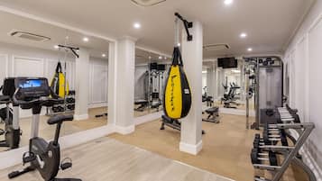 A gym with exercise equipment, including an elliptical, punching bag, and weight machines.