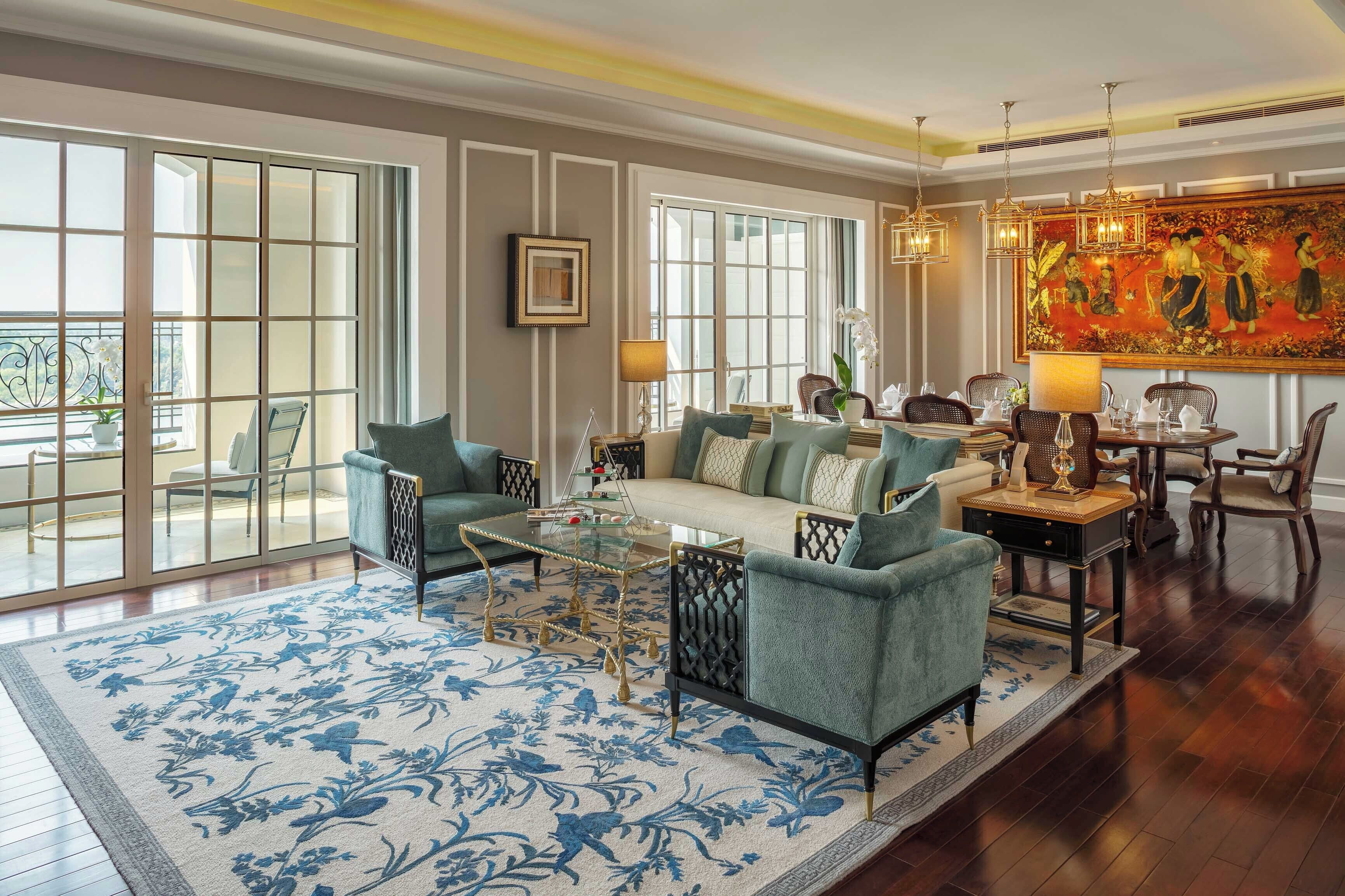 A spacious living area with a sofa, armchairs, a coffee table, and a dining table set for four.