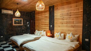 A hotel room with two wooden beds, a checkered floor, a stone wall, and a wooden ceiling. - Historic Eco House & Ha Giang Loop (Ha Giang 2)
