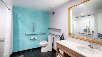 Un baño moderno con inodoro, lavamanos y ducha.