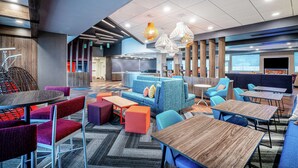 Un espace de détente moderne, aménagé avec des sièges, des tables et un grand écran.