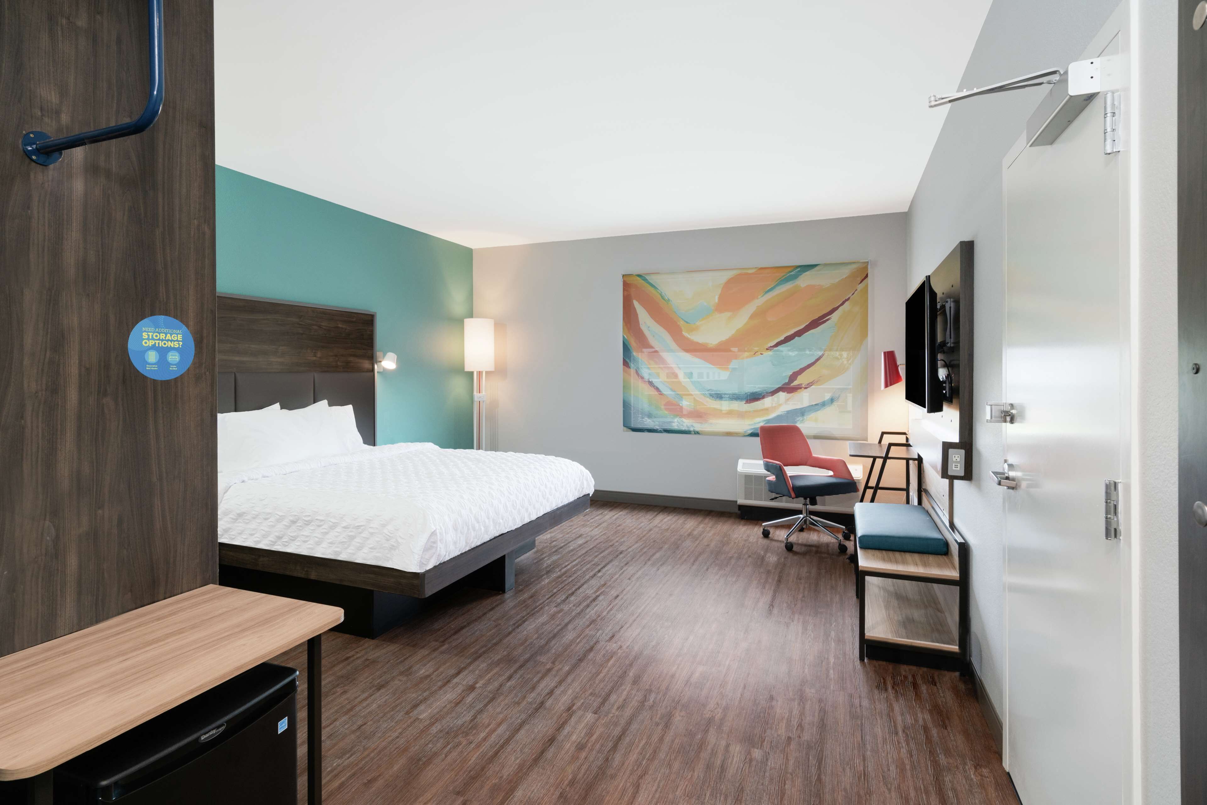 Een hotelkamer met een bed, bureau, stoel en een televisie.