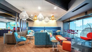 Un espace de détente moderne, doté de sièges, de tables et de luminaires suspendus.