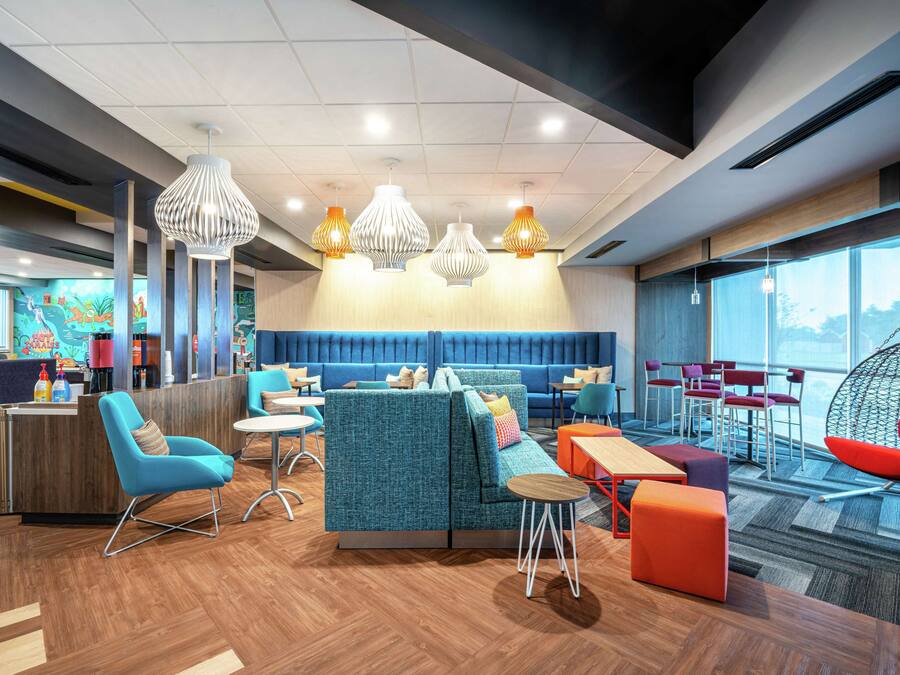 Un espace de détente moderne, doté de sièges, de tables et de luminaires suspendus.
