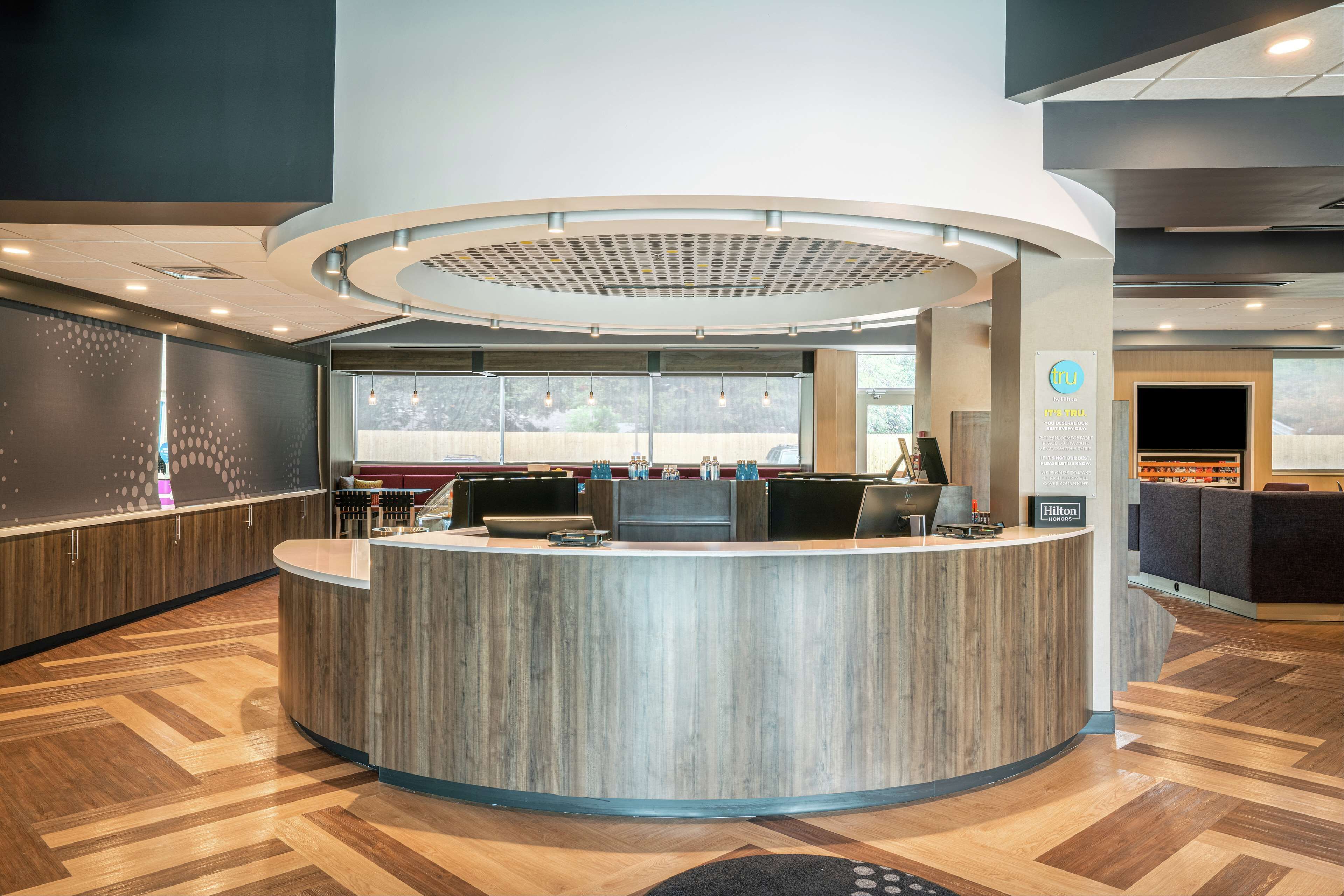 A modern reception area with a curved counter, large windows, and a view of the outdoors.