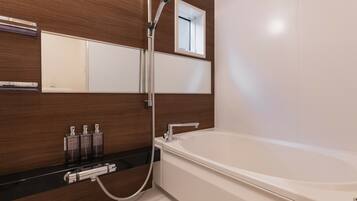 Een aparte badkuip en douche, gratis toiletartikelen, een haardroger