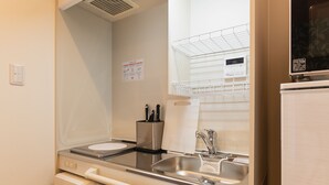 A compact kitchenette with a sink, a microwave, and a small countertop.