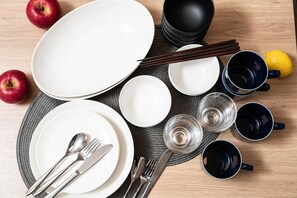 A neatly arranged dining setup with plates, cutlery, chopsticks, and glasses on a woven placemat. - MIMARU Tokyo Ueno Okachimachi (Tokyo)