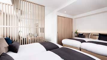 A modern hotel room with a large bed, a desk, and a sliding door.
