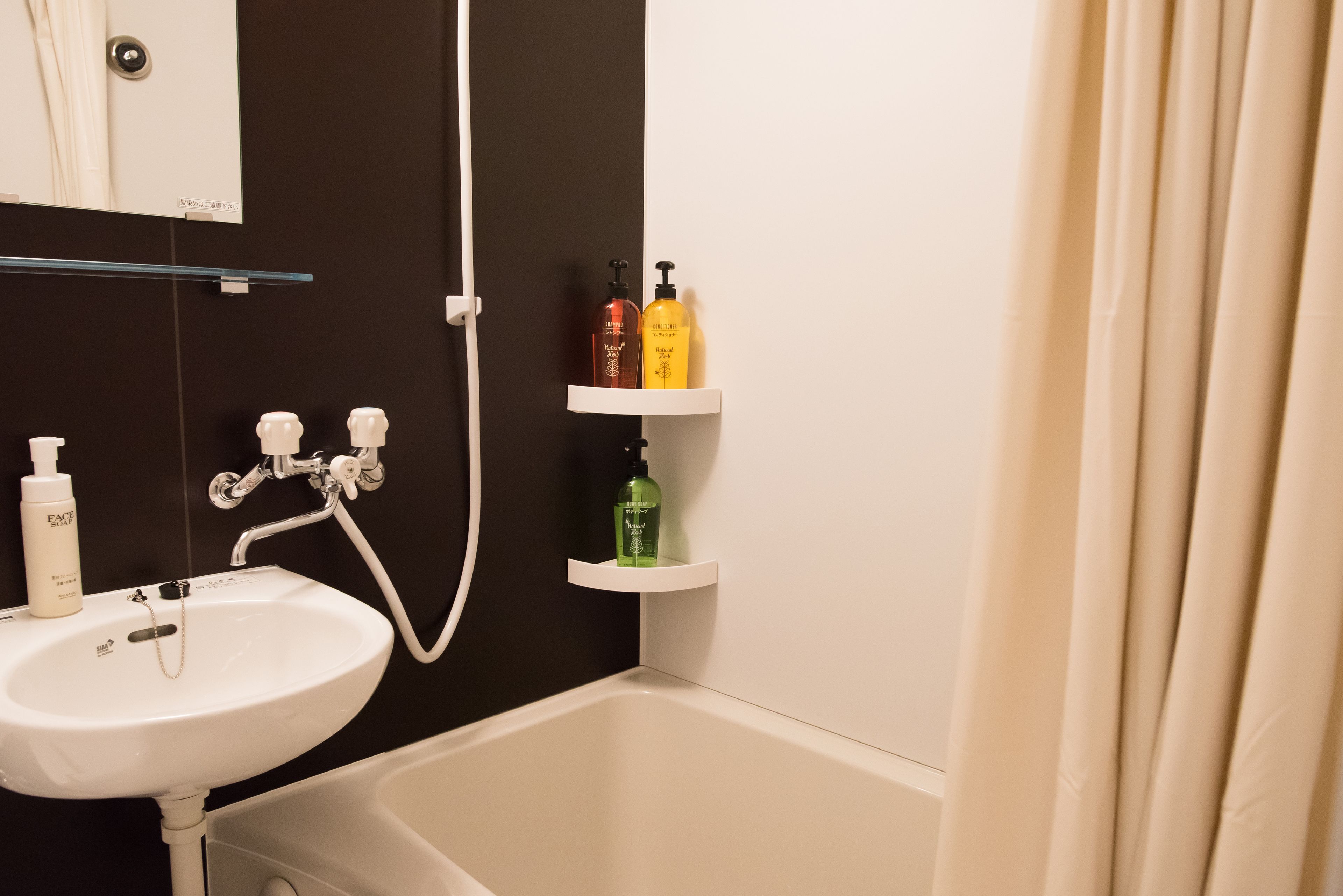 A bathroom with a white sink, a bathtub, and shelves holding toiletries.