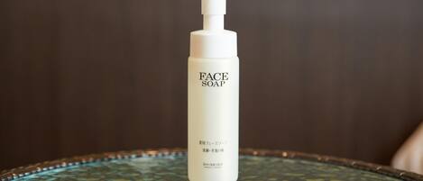 A bottle of face soap on a glass table.