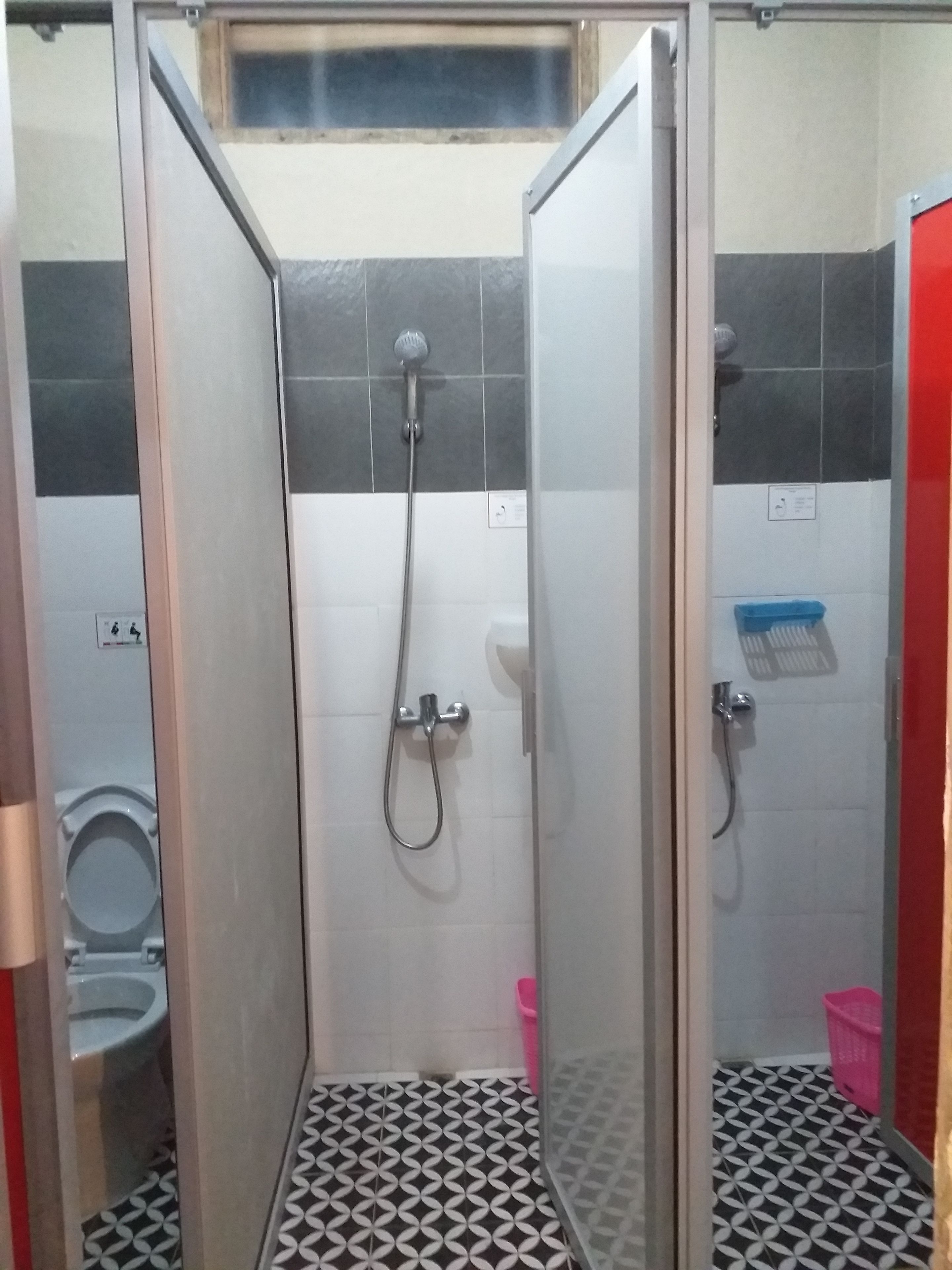 Cabina de ducha con puerta de vidrio, ducha y manopla.