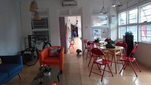 Uma sala de estar moderna com um sofá, uma mesa de jantar com cadeiras e uma bicicleta.