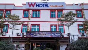 A hotel with a red and white facade, multiple windows, and a sign indicating it is now open.