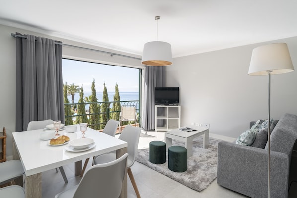 Enjoy a coastal view from the large window, with a dining area and comfortable seating for two.