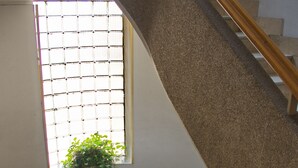 Una escalera en espiral con barandilla de madera y escalones cubiertos de moqueta beige.