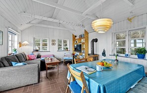 Relax in a spacious room with a comfortable seating area, dining table, and bookshelf.