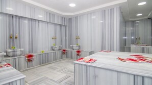 A bathroom with marble walls, multiple sinks, and a large mirror. - An Grand Hotel (Ankara)