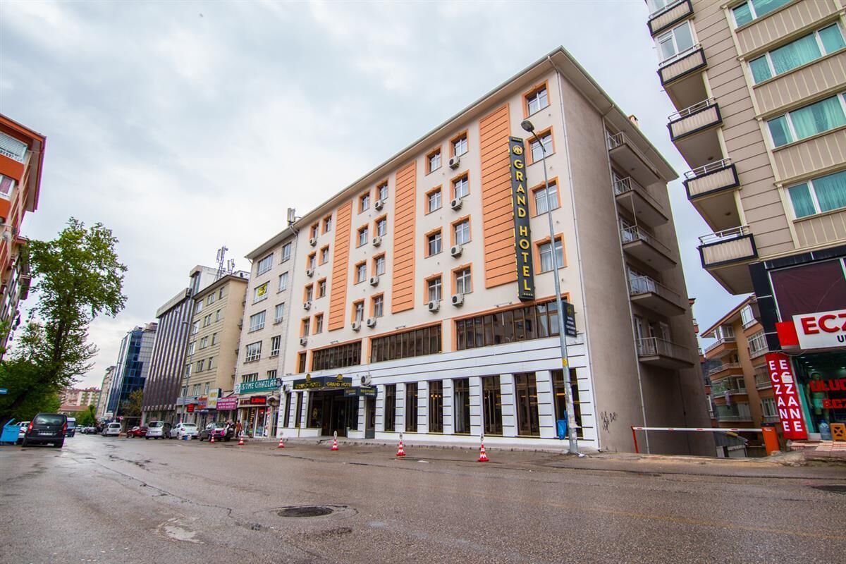 A multi-story hotel with a prominent entrance, several balconies, and a clear view of the street.