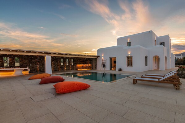 Un edificio moderno con piscina, zona de estar exterior y bar.