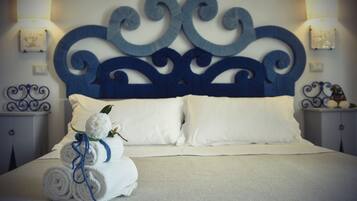A neatly made bed with white linens and a decorative headboard.