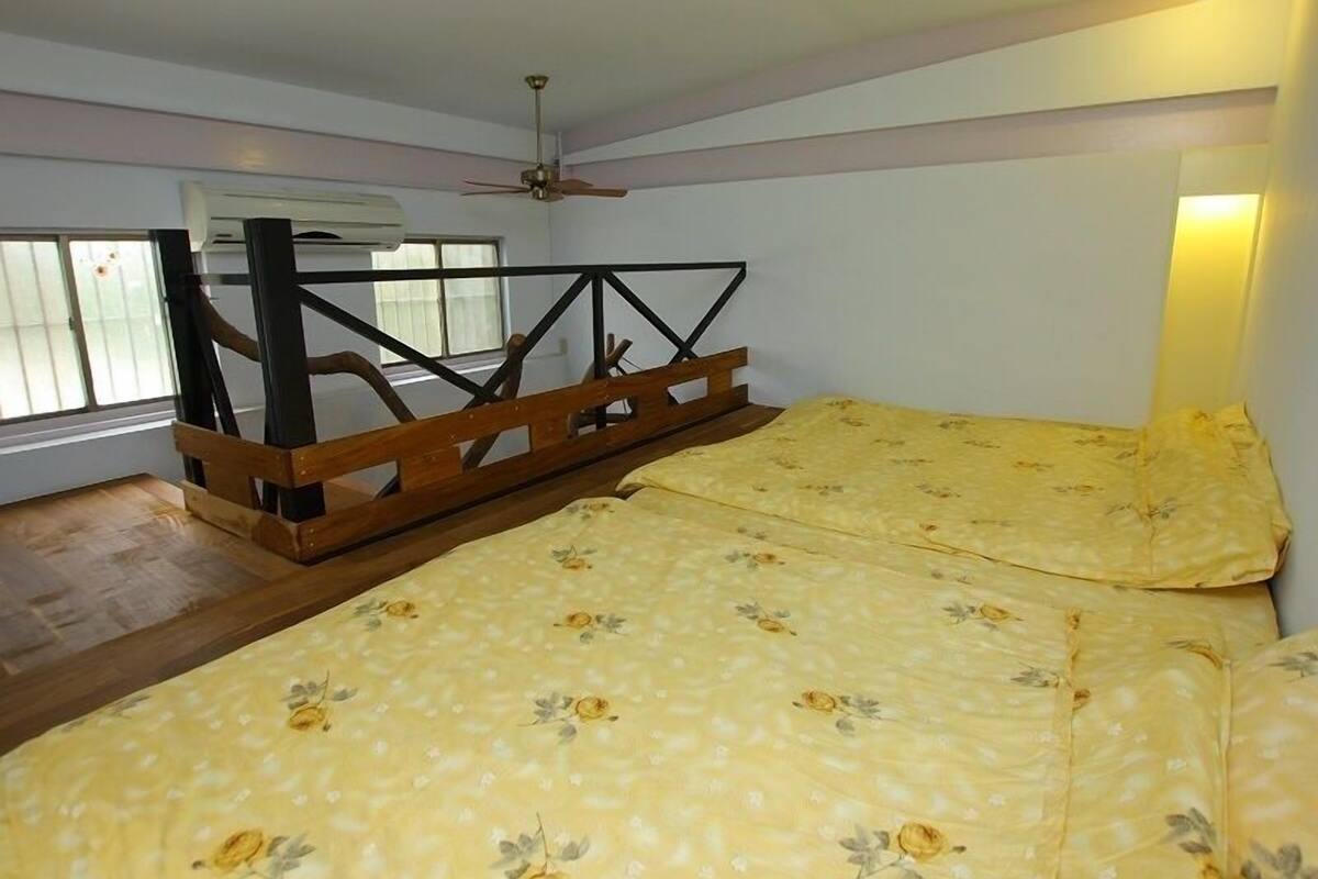 A bedroom with a bed, a ceiling fan, and a window with blinds.