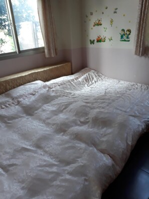 A bedroom with a bed, a window, and wall decorations.