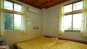 A room with two beds, a window with curtains, a tiled wall, and an air conditioning unit. - Duan Yuan Homestay (Lukang)