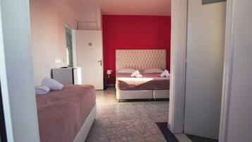 A hotel room with a bed, a desk, and a door marked with the number 16.
