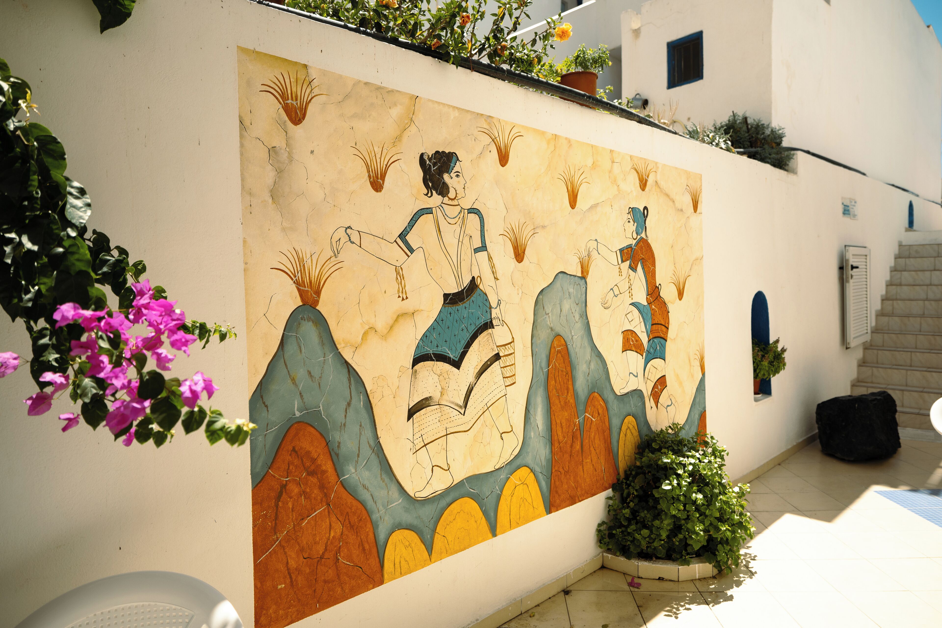 Un murale raffigura una donna a cavallo, una scala e piante in vaso.