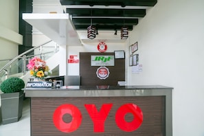 Un mostrador de recepción de hotel con un letrero que dice "OYO" y "JRJF HOTEL".