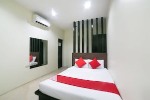 Habitación de hotel con una cama grande, un espejo, un equipo de aire acondicionado y una ventana con persianas verticales.