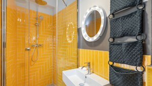 Bagno con doccia, lavandino e specchio illuminato.