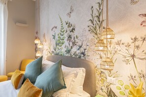A bedroom with a floral wallpaper, a bed with multiple pillows, and hanging light fixtures. - Rome as you feel - Pellegrino Suite in Navona (Rome)