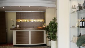 A reception area with a wooden reception desk, potted plants, and a wine display.