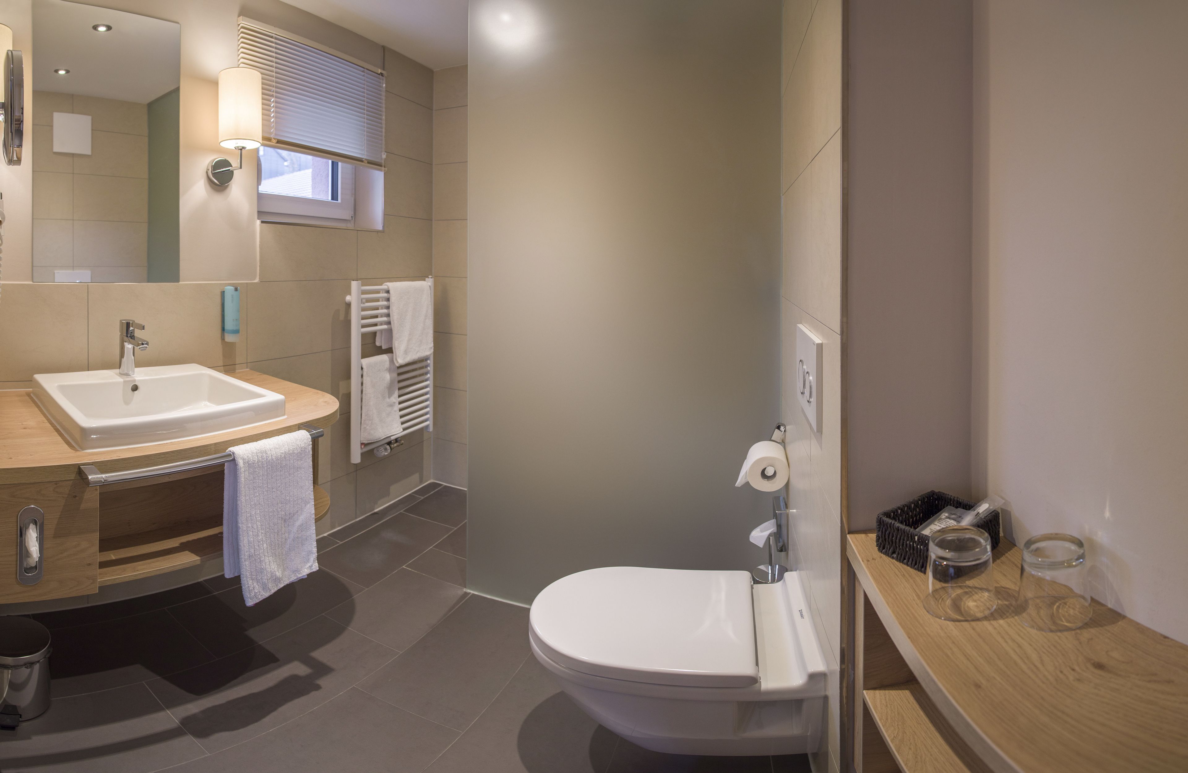 A modern bathroom with a sink, toilet, and vanity.