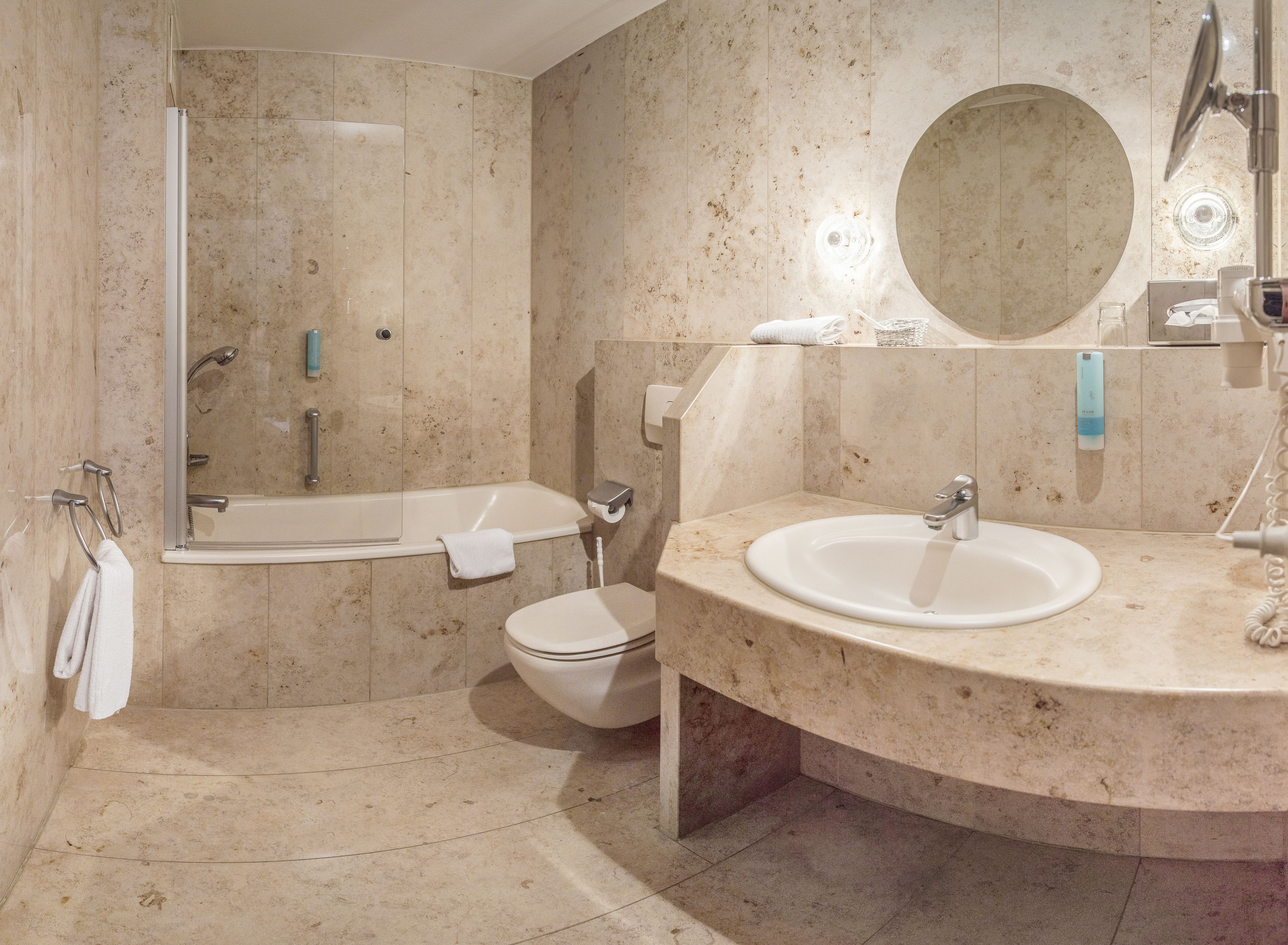 A bathroom with a bathtub, toilet, and sink.