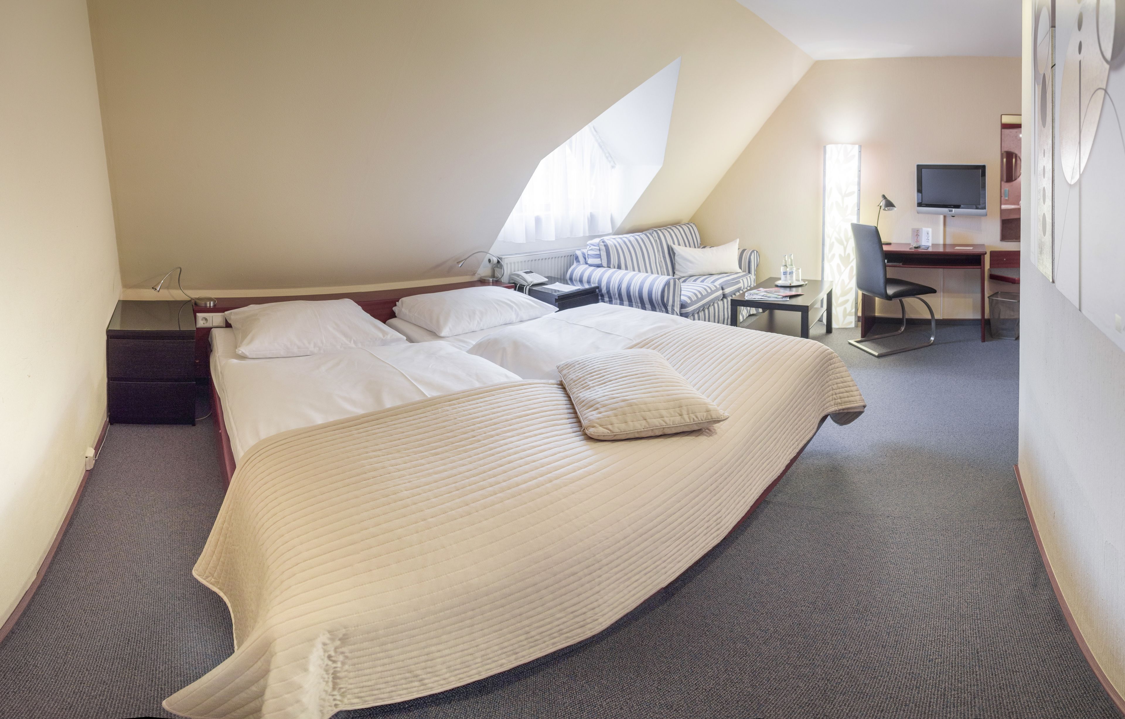 Une chambre à coucher avec un grand lit, un bureau, une chaise et un téléviseur.