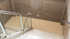 Un escalier moderne avec des rampes en verre et des carreaux de couleur beige.