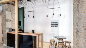 Uma cozinha moderna com uma mesa de madeira, banquetes e luminárias pendentes.