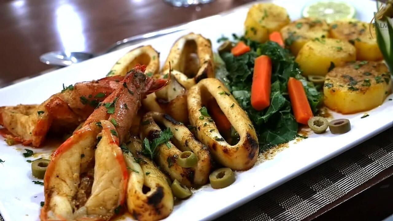 Ein Teller Essen mit gegrilltem Hähnchen, Kartoffeln und Gemüse.