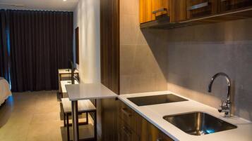 Una cocina moderna con dos fregaderos, armarios de madera y un comedor con banco y mesa.