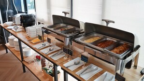 A buffet setup with various food options and serving utensils. - Kokotel Bangkok Sukhumvit 50 (Bangkok)